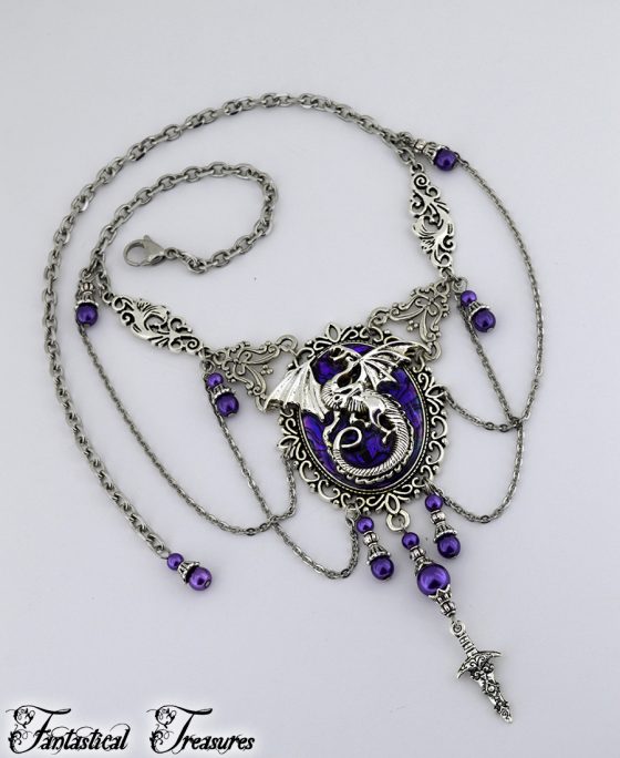 Purple fantasy dragon necklace laid out on white background